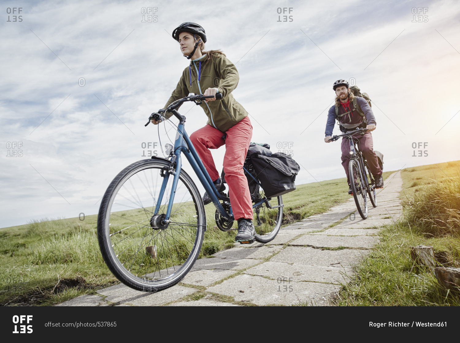 Germany - Schleswig-Holstein - Eiderstedt - couple riding bicycle through salt marsh