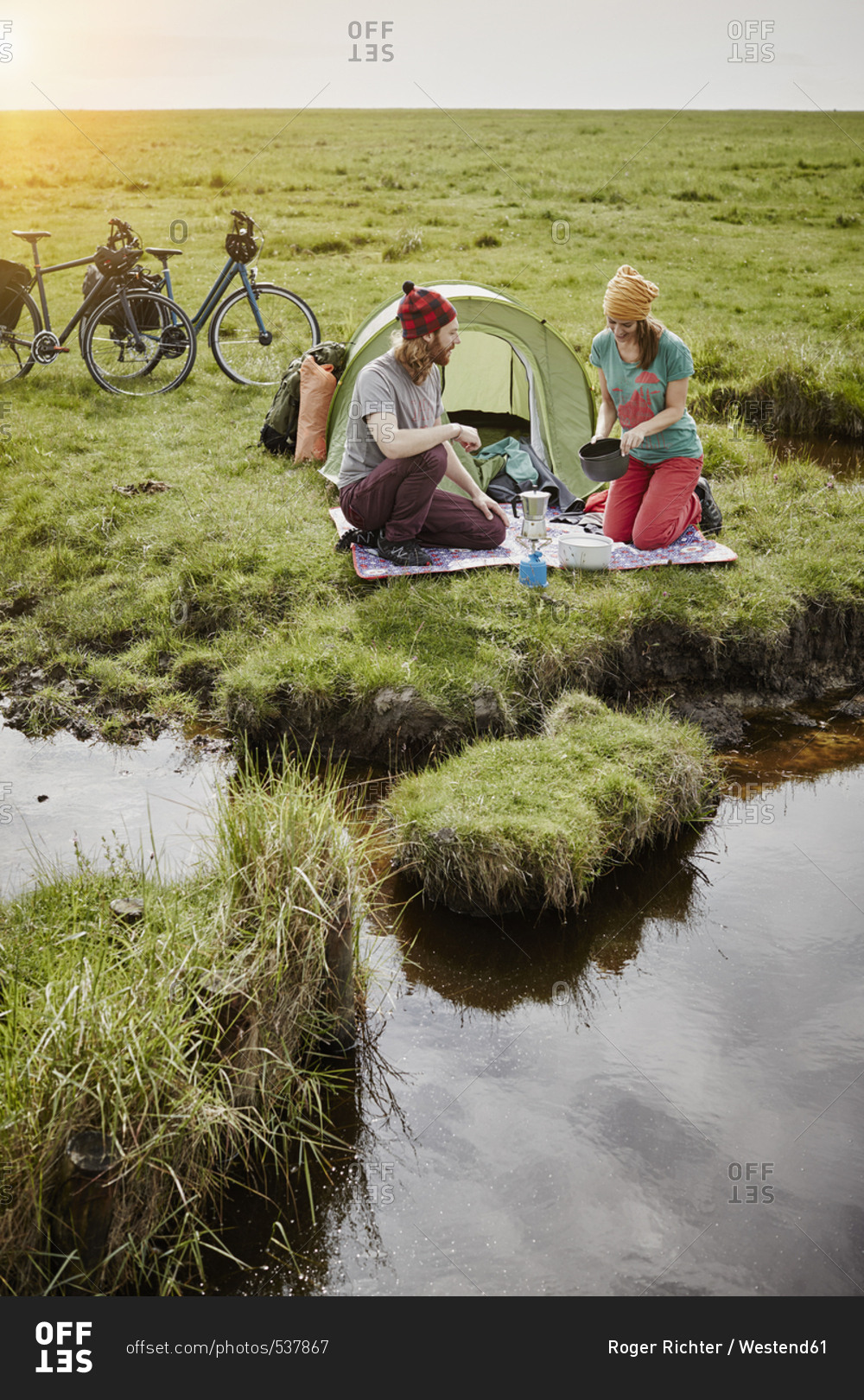 Germany - Schleswig-Holstein - Eiderstedt - couple with bicycles camping in marsh landscape