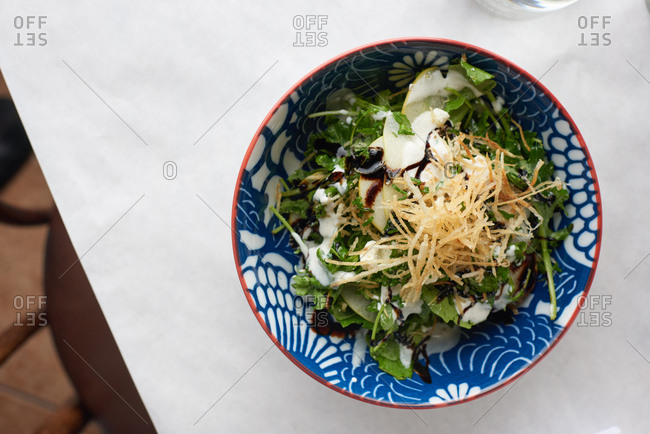 Kale Salad with fried thin croutons and apple served with balsamic and creamy dressing served in a French restaurant.