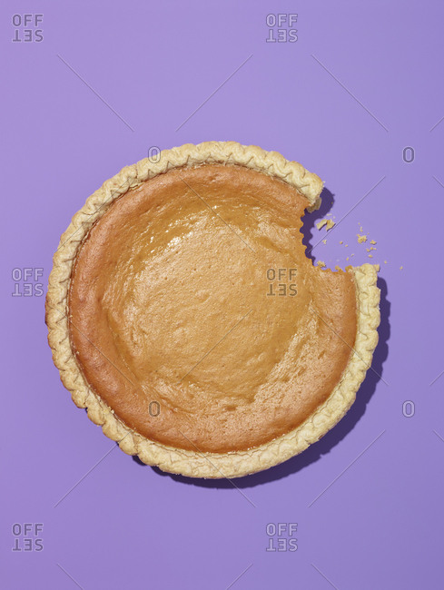 Whole pumpkin pie with bite missing