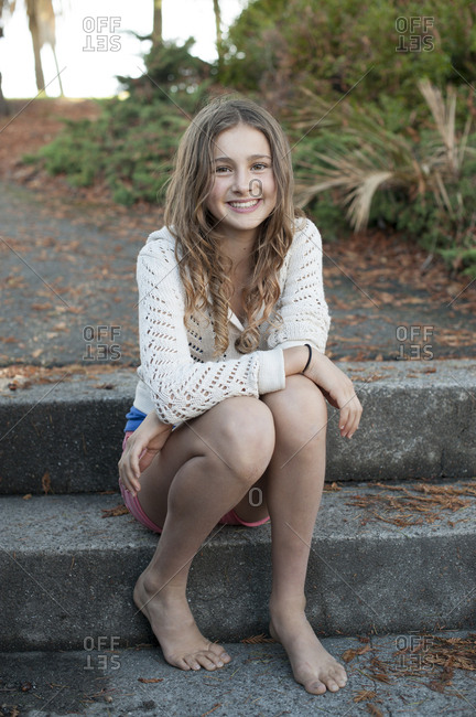 Barefoot girl sitting on park steps stock photo image pic