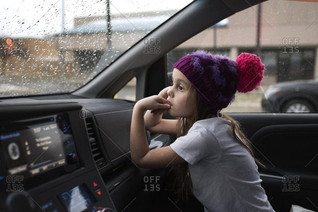 Girl in hat waiting in front seat of car