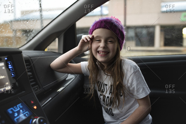Happy young girl in front seat of car