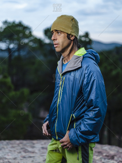 Portrait of athletic rock climber at dusk looking into the distance in Albarracin, Spain