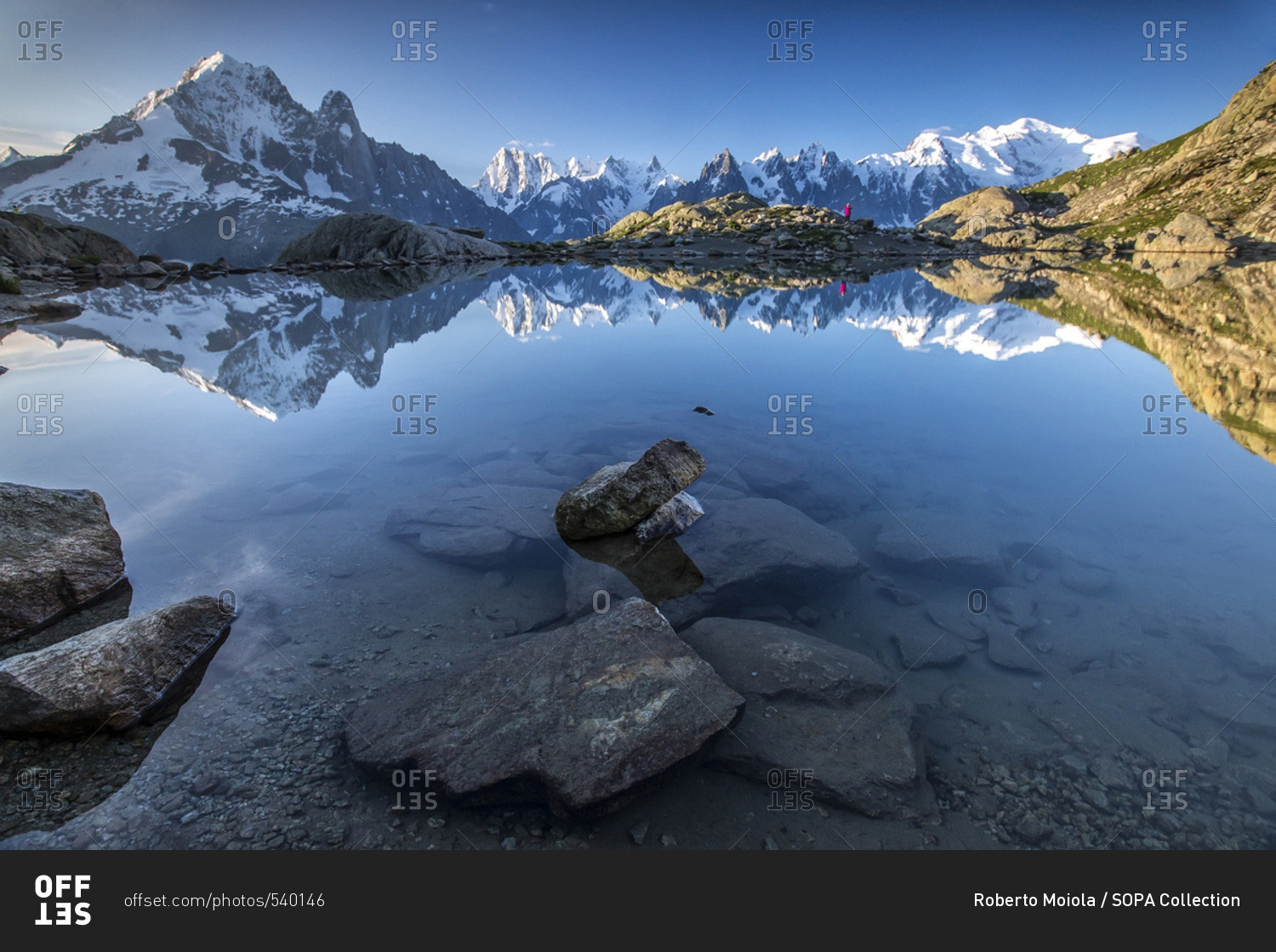 Snowy peaks of Aiguilles Verte Dent Du Geant and Mont Blanc are reflected in Lac Blanc