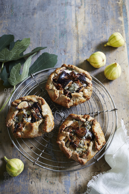 Three fig tarts on cooling rack with whole figs