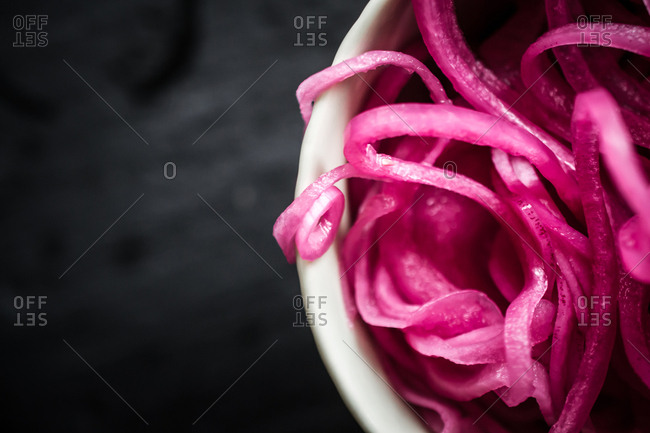 Red onion slices in bowl