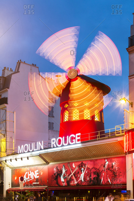 Illuminated windmill on Moulin Rouge against sky at dusk