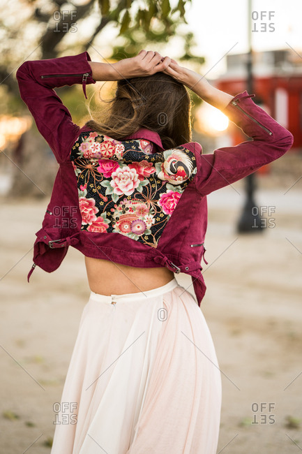 Vertical back view of stylish young woman posing outside, stock photo -  OFFSET