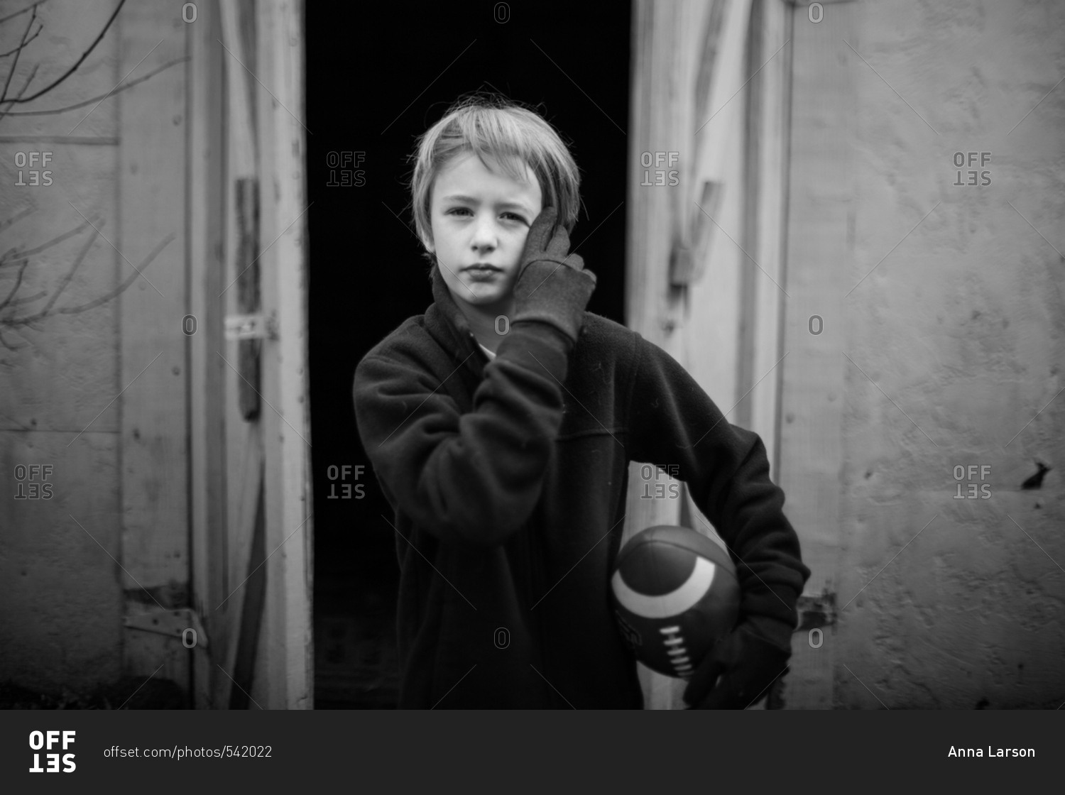 Boy holding football in black and white