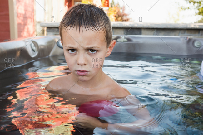 Portrait of grumpy boy in hot tub