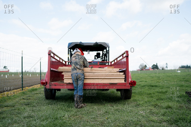 Back view of boy resting on lumber in cart