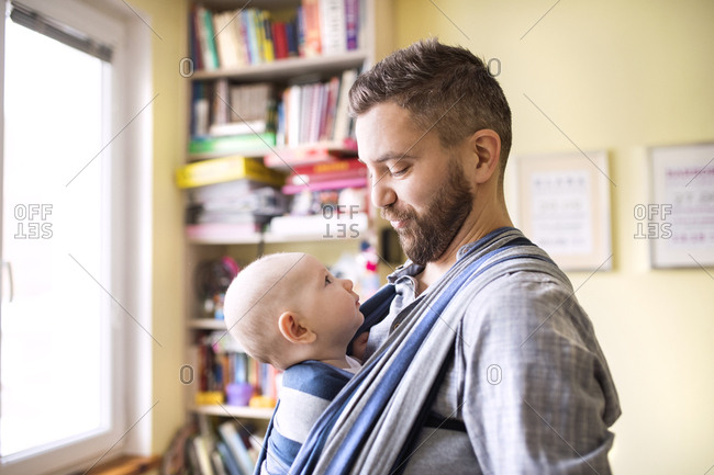  Father  with baby  son in sling  at home stock photo OFFSET