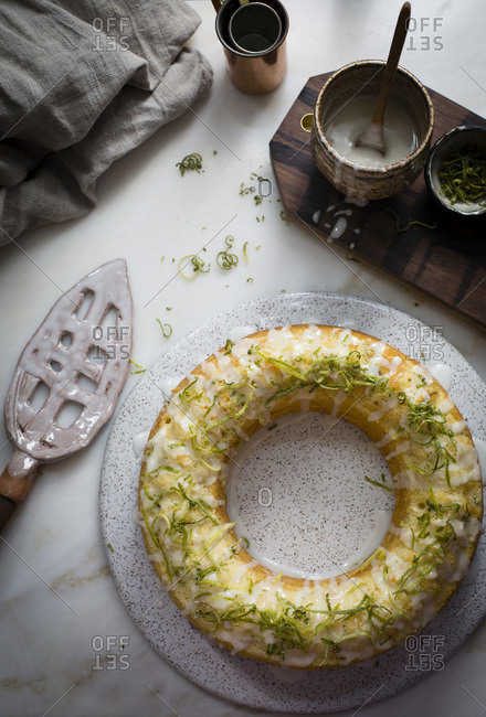 Key lime bundt cake  glazed with key lime glaze and topped with lime zest on a marble table on top view