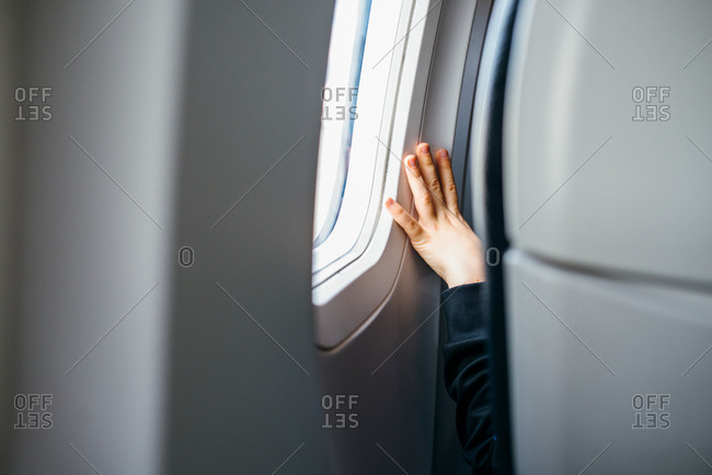 Child's hand on airplane window
