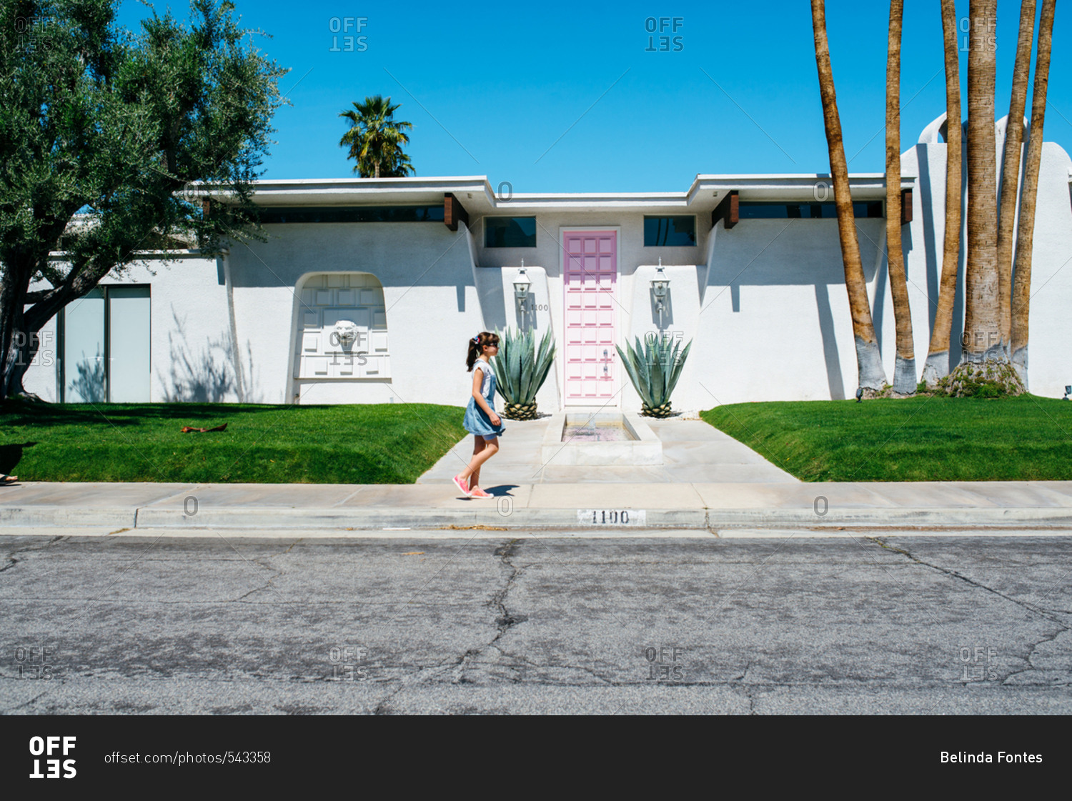 Girl walking past mid-century house in Palm Springs