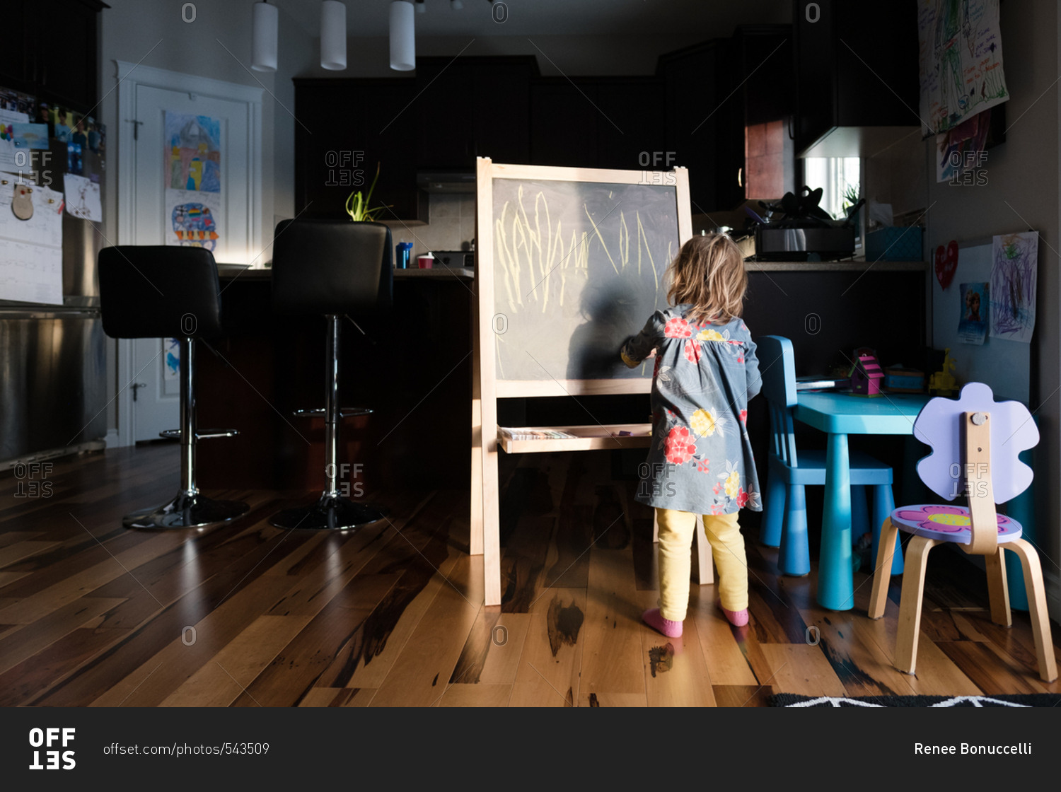 Girl drawing on a chalkboard easel at home