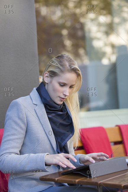 Pretty blonde woman with tablet in a Cafe