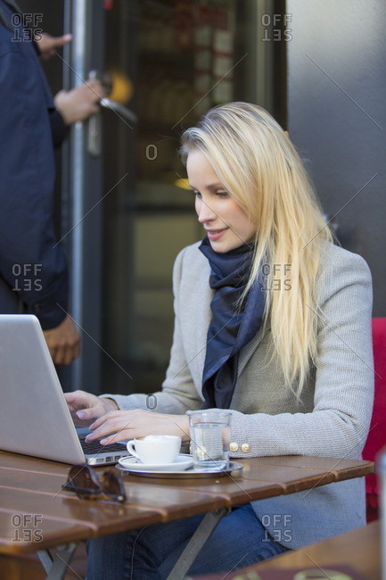 Pretty blonde woman with laptop in a Cafe