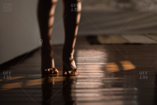 Barefoot child walking on hardwood floors