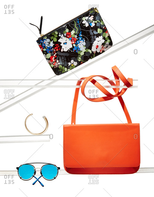 Handbags, bracelet and sunglasses on glass display tubes