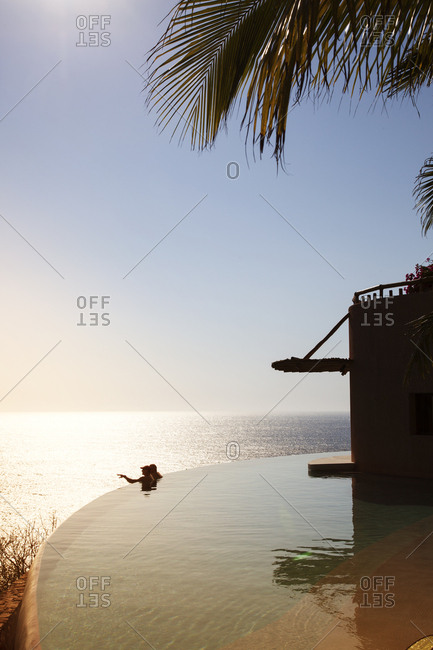 Mid distance view of friends in infinity pool against sky