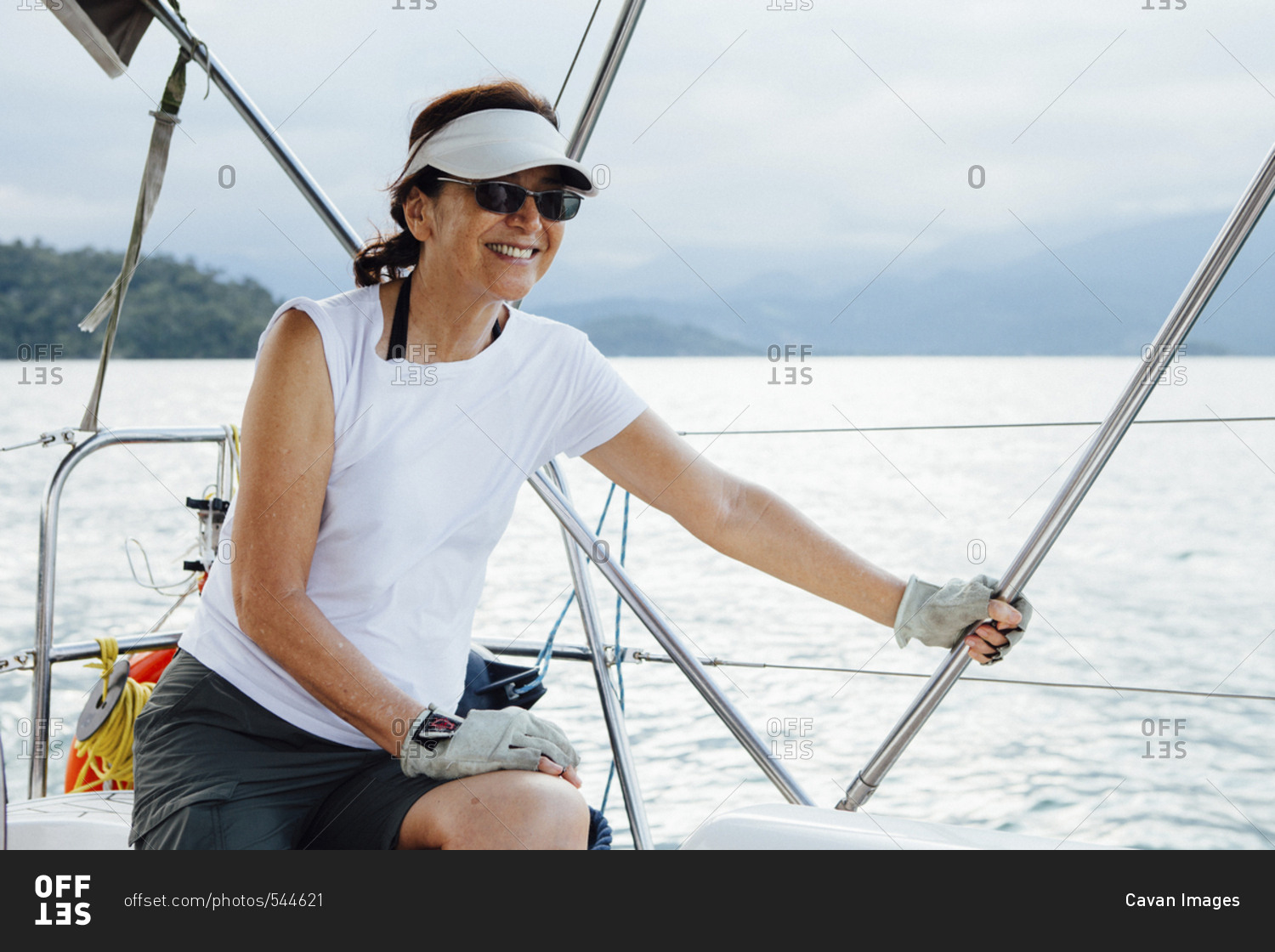 Happy woman sitting in sailboat on sea