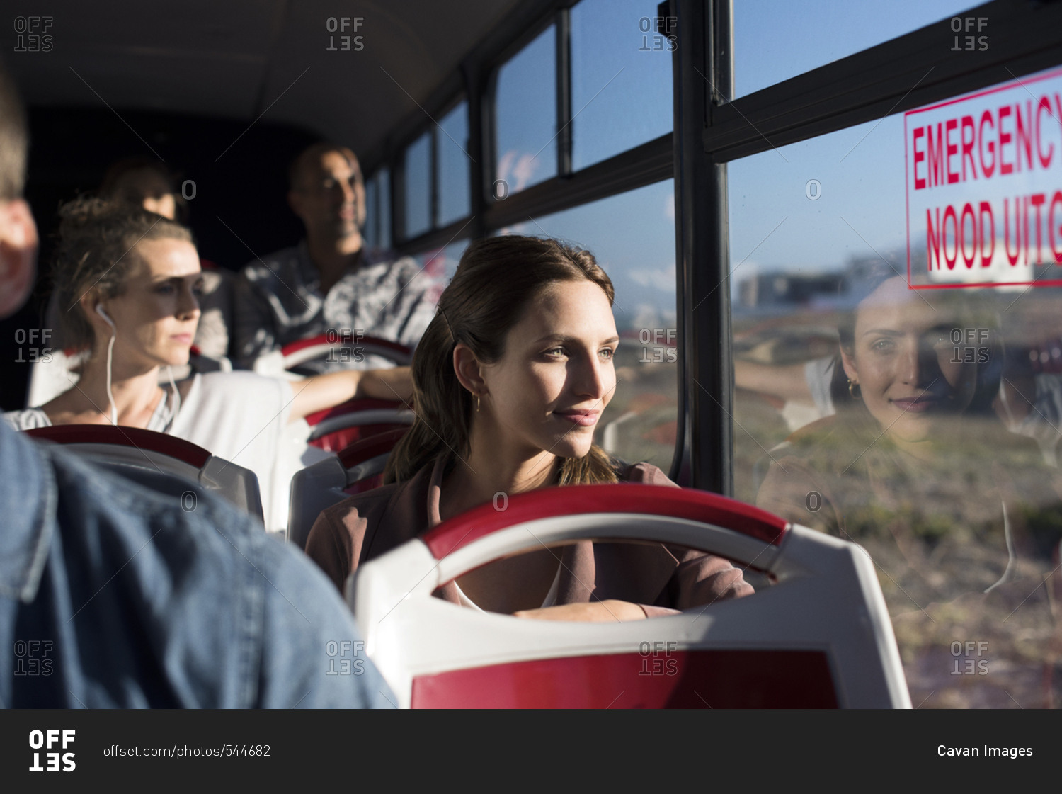 Passengers looking through window while traveling in tour bus