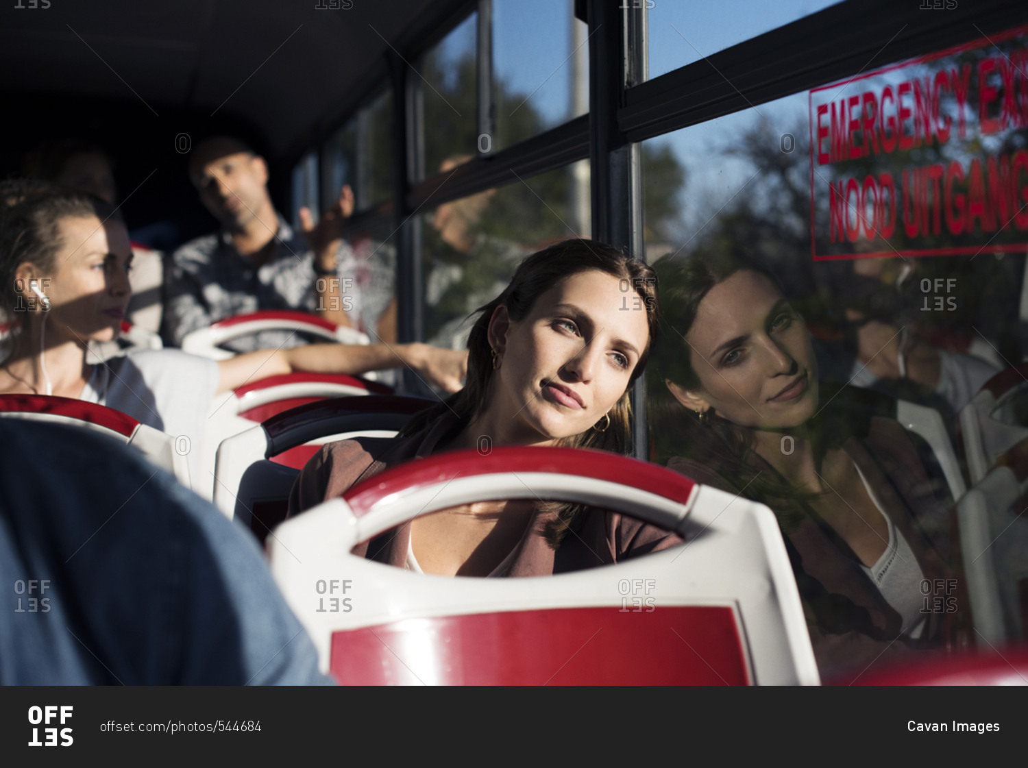 Tourists looking through window while traveling in bus