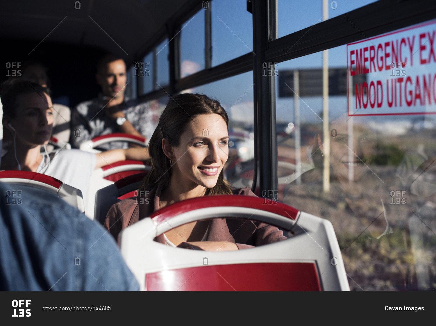 Tourists looking through window while traveling in tour bus