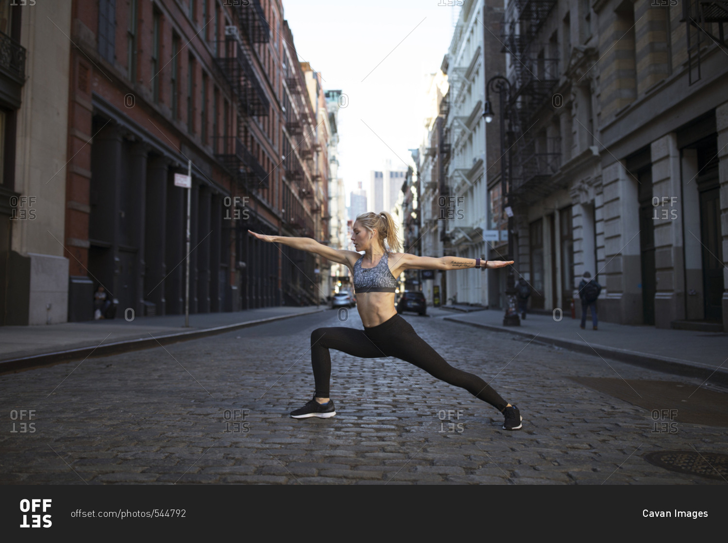 Female athlete exercising on street in city