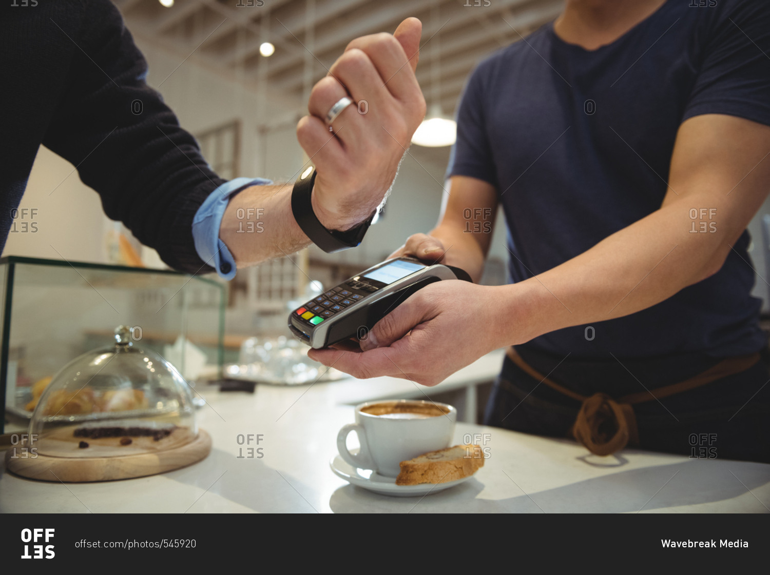 Customer paying with NFC technology on smart watch in coffee shop