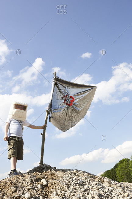 Little boy dressed up as spaceman playing moon landing