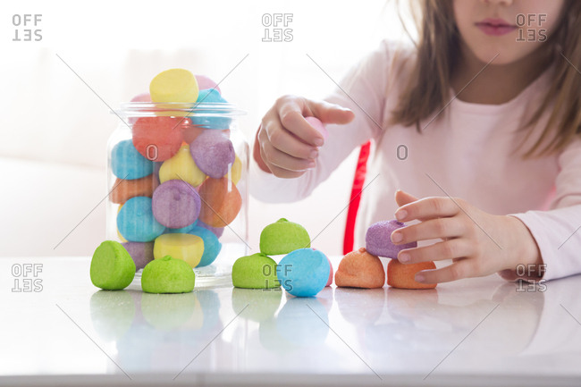 Little girl playing with marshmallows