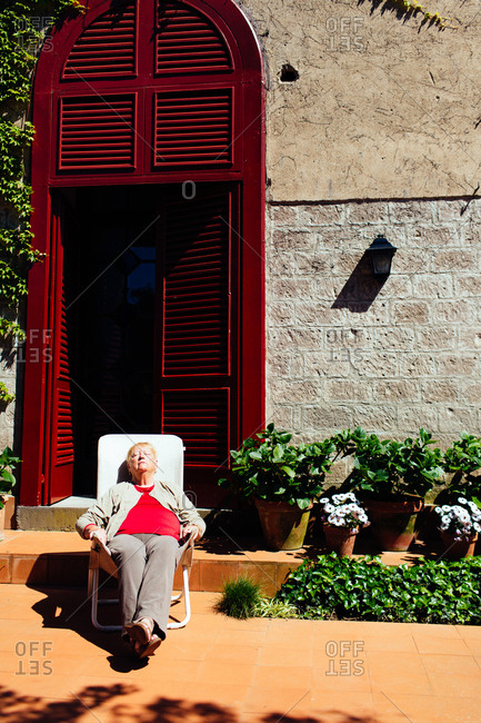 Piano di Sorrento, Italy - April 21, 2015: Senior woman in a chair in a courtyard taking a nap
