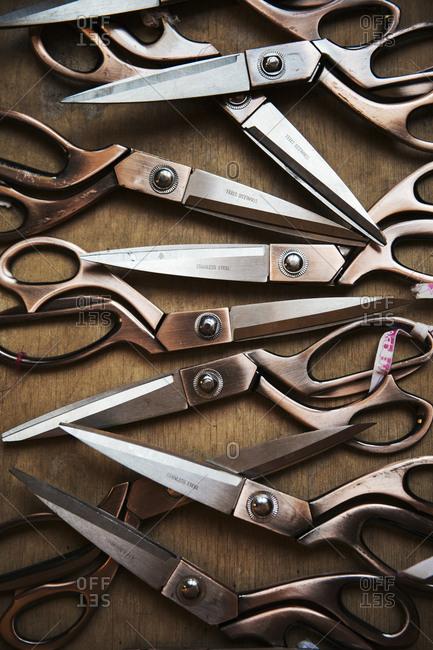 A row of used and worn scissors on a tabletop