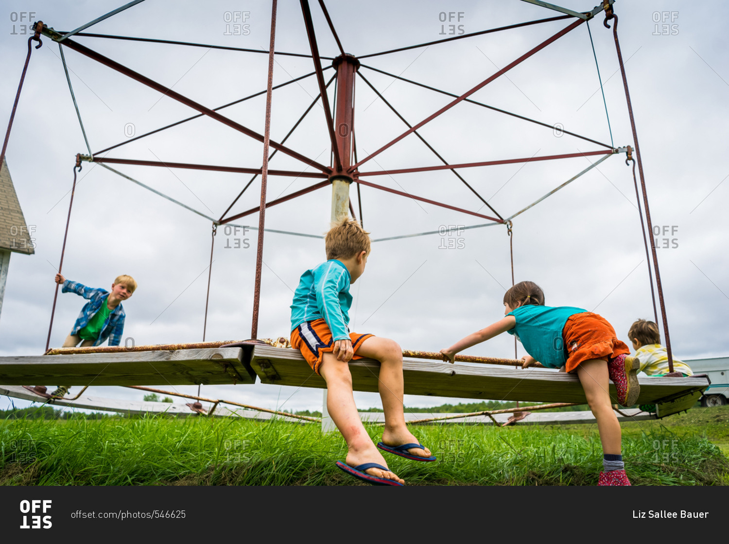 Four kids playing on old playground equipment