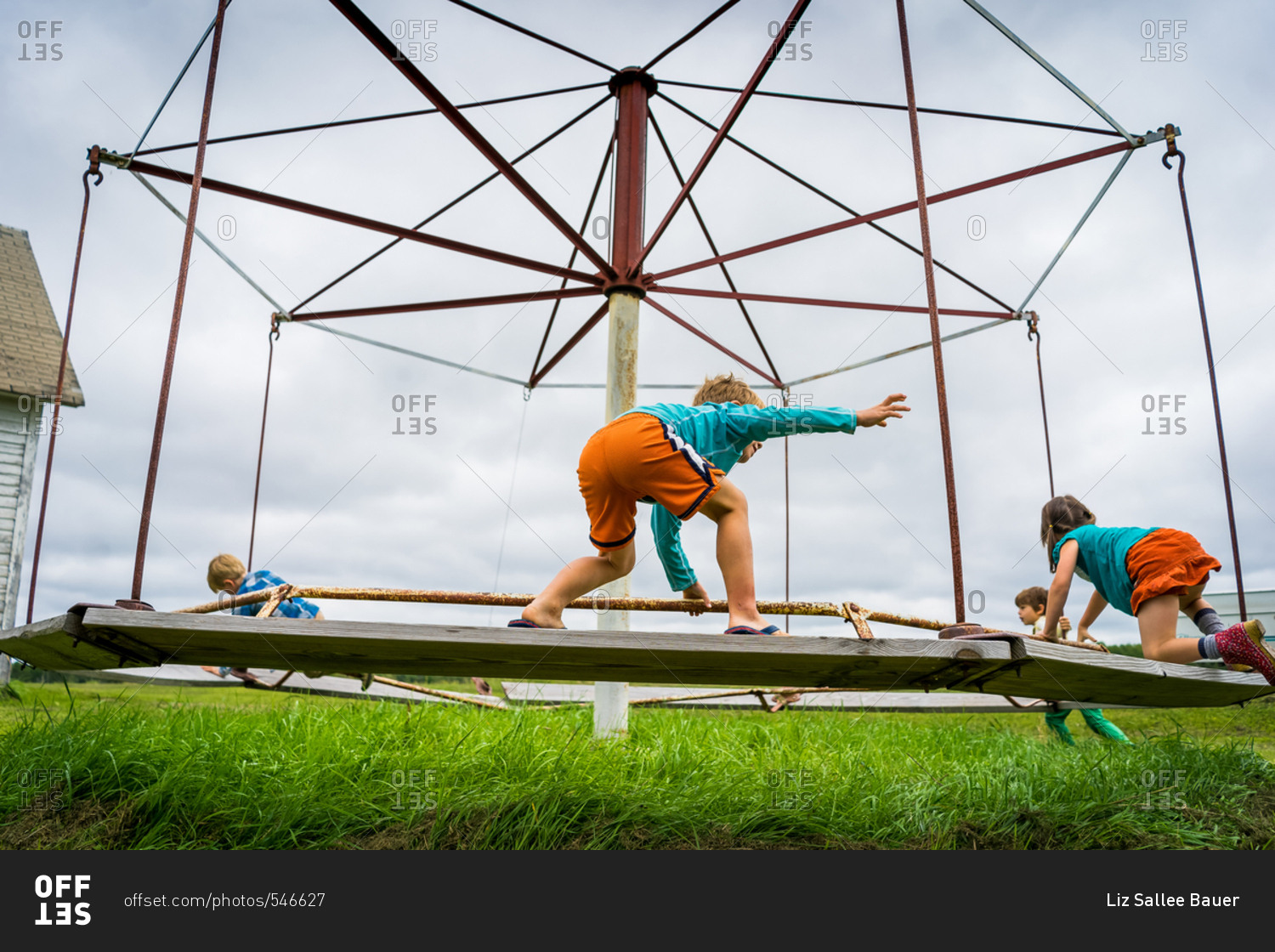 Four kids playing on old playground equipment