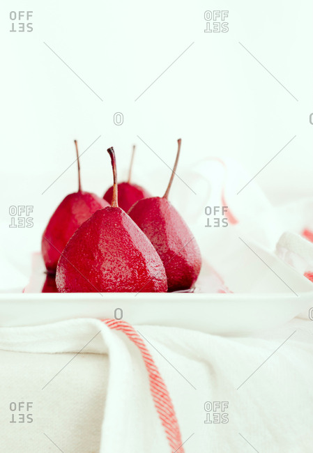 Scarlet poached pears on a white plate