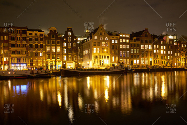 Amsterdam, Netherlands - January 18, 2017: Ships at night in a canal in Amsterdam