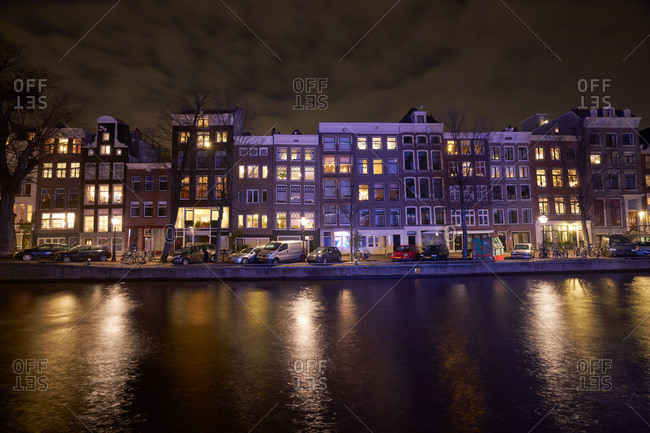 Amsterdam, Netherlands - January 18, 2017: Row houses along a canal in Amsterdam at night
