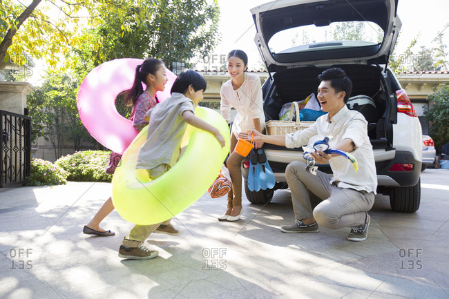 Young family putting water sports equipment into the car