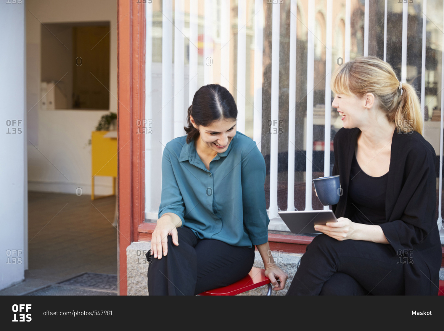 Smiling mid adult businesswomen sitting outside office