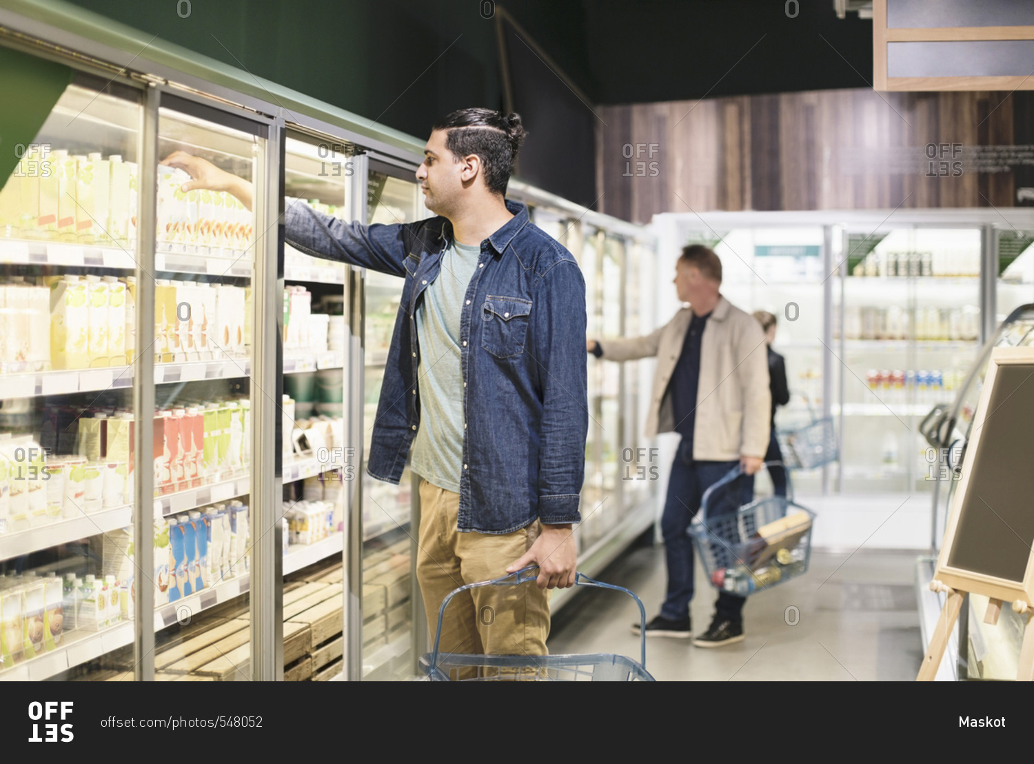 Customers shopping at refrigerated section in supermarket