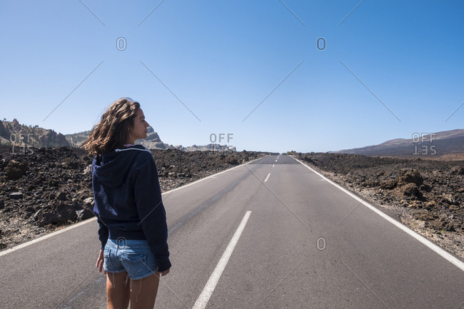 Young woman looking into the distance on road in Tenerife, Canary Islands, Spain