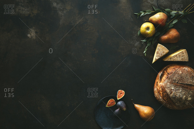 Still life scene with bread, fruits, and cheese