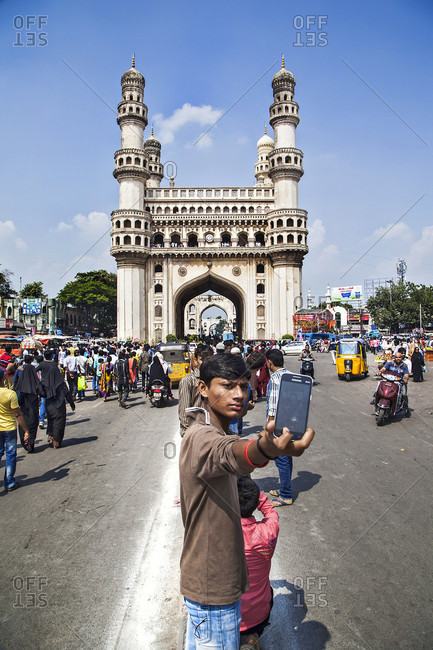 Hyderabad, South India, India - October 18, 2015: A boy take selfie with Char Minar. Constructed in Islamic architecture using pulverised marble, limestone, mortar and granite