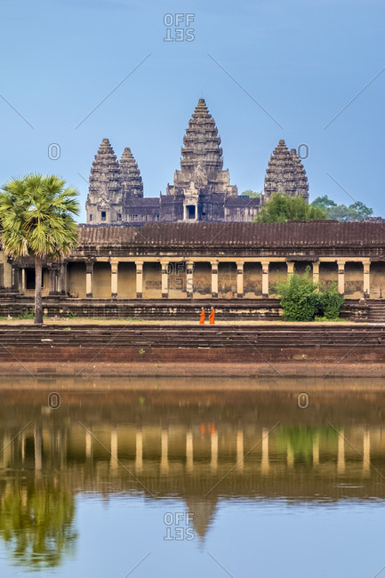 Krong Siem Reap, Siem Reap, Cambodia - April 23, 2015: Two monks passing in front of Angkor Wat, UNESCO World Heritage Site, Siem Reap Province, Cambodia