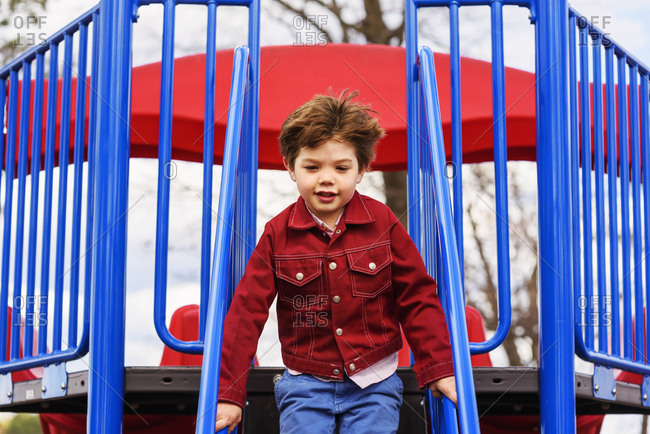 Young boy trying to do the monkey bars at a playground