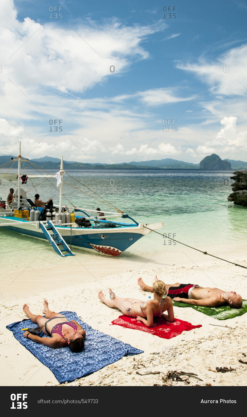 Sun Bathers Relaxing On The Shore Of An El Nido Beach, Palawan, Philippines